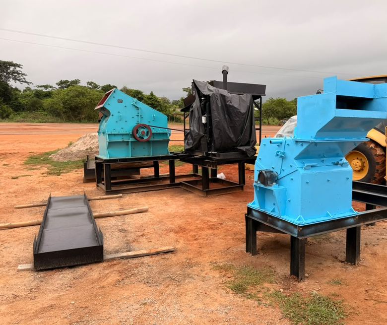 Plusieurs machines bleues sur bâtis noirs, sur un terrain de latérite